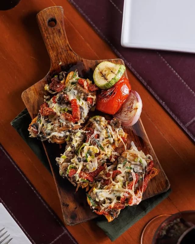 Bruschetta de cogumelos e tomate seco na tábua do ¡Vení! Parrilla