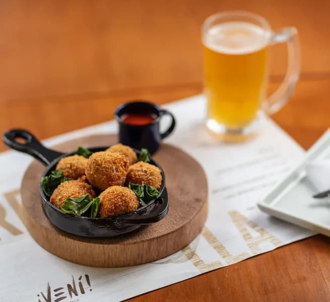Croquetes de siri servidos na frigideira no ¡Vení! Parrilla