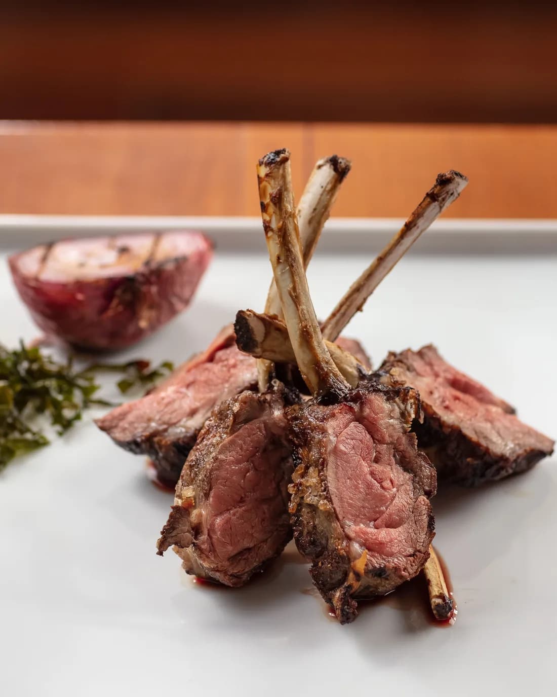 Short rack de cordeiro Patagônia fatiado e servido no ¡Vení! Parrilla